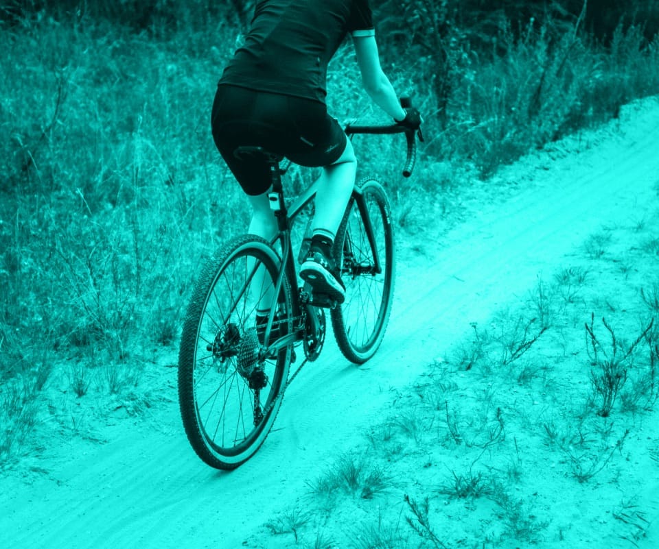 Gravel-Bike-Fahrer auf Sandweg im Wald
